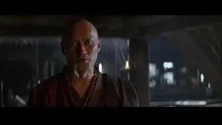 Bald man in red robe with city skyline — Batman