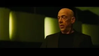 bald man in suit on green stage — Whiplash