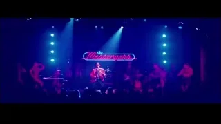 band performing on stage with neon sign — La La Land