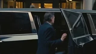 Black SUV driving on wet city street — Succession