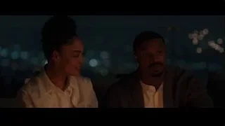 couple on bench looking at tablet at night — Creed 3