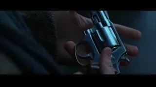 Hand holding a silver revolver in dark room — Batman