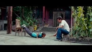 man and child lying in courtyard — The Karate Kid