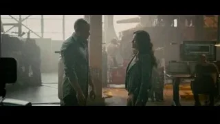 Man and woman conversing in industrial space — Furious Seven