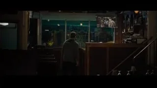 man in hoodie at bar counter with screen — Creed 2