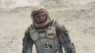 Man in NASA suit in rocky landscape — Interstellar