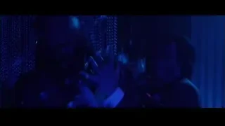 Man in suit holding gun with neon lights — John Wick
