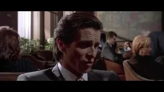 man in suit in bar raising hand — American Psycho