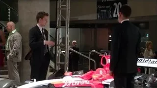 man in suit next to race car — Suits