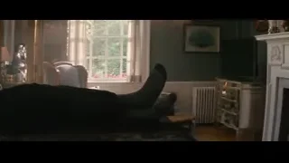 man in suit sitting on living room couch — Deadpool 2
