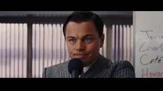Man in suit speaking into microphone in office — The Wolf Of Wall Street