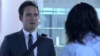 man in suit talking to woman by window — Suits