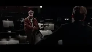 man performing with orchestra in dark room — Steve Jobs