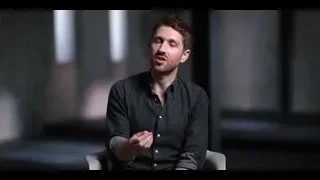 Man with beard sitting in dark room gesturing — The Social Dilemma