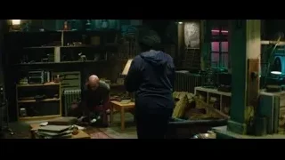 man working on furniture in cluttered room — Deadpool 2