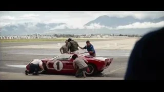Men working on red sports car on runway — Ford v Ferrari