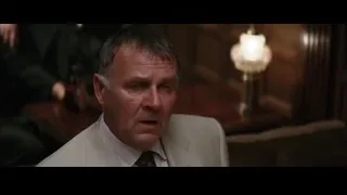 Older man in suit in dimly lit room — Batman