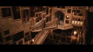 People walking up ornate staircase in dimly lit room — Harry Potter and the Philosophers Stone