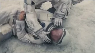 person in space suit kneeling on ground — Interstellar