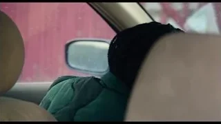 person sitting in car on street — The Bear