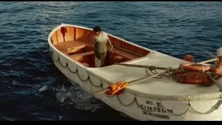 small wooden boat with lifebuoy on water — Life of Pi