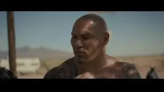 tattooed man in desert holding glove — Creed 2