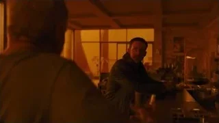 Two men at bar counter in dimly lit room — Blade Runner 2049