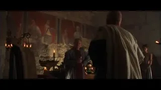 two men in robes holding wine in dim room — Gladiator