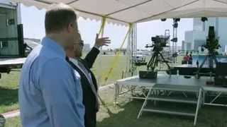 Two men under tent on grassy field — Elon Musk: Return to Space