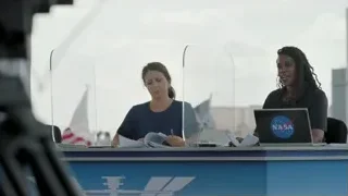 Two women in NASA shirts working at desk — Elon Musk: Return to Space