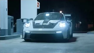 White Porsche race car parked at night — Sports Cars