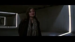 woman standing in dimly lit concrete room — Batman: The Dark Knight Rises