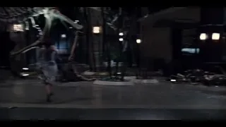 woman walking towards dinosaur skeleton — Jurassic World