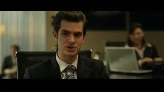 Young man in suit sitting at office desk — The Social Network