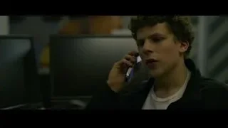 young man talking on phone at computer — The Social Network